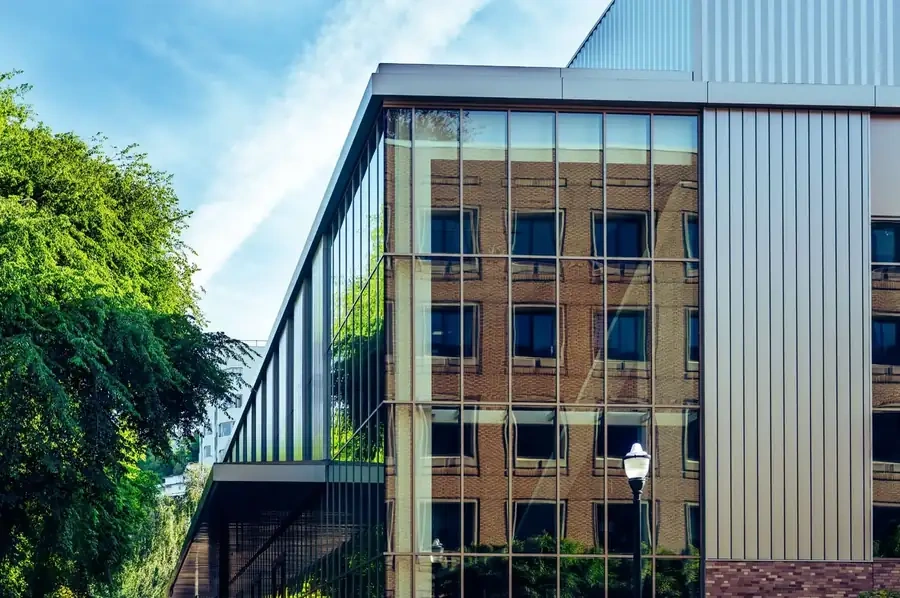 Certified installer applying 3M window film to a commercial glass facade in Tampa